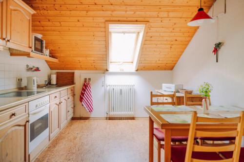 Küchenansicht der Ferienwohnung mit Küchenzeile, Essbereich sowie Dachfenster.